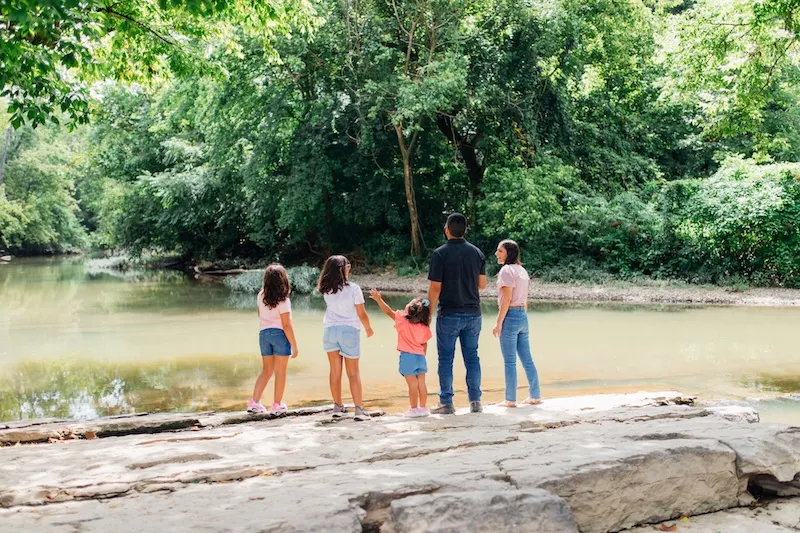 Family standing by a creek surrounded by trees in Ringgold, Georgia