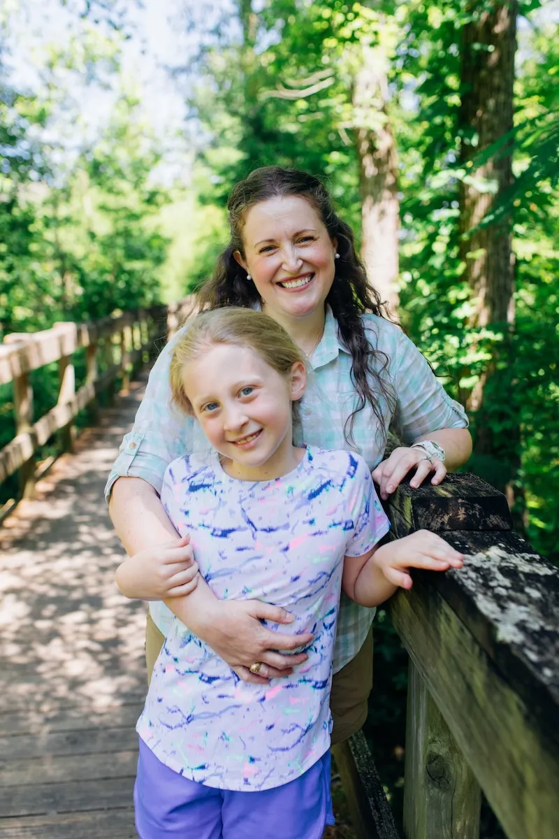Mother and child on a wooden bridge surrounded by trees in Ringgold, Georgia