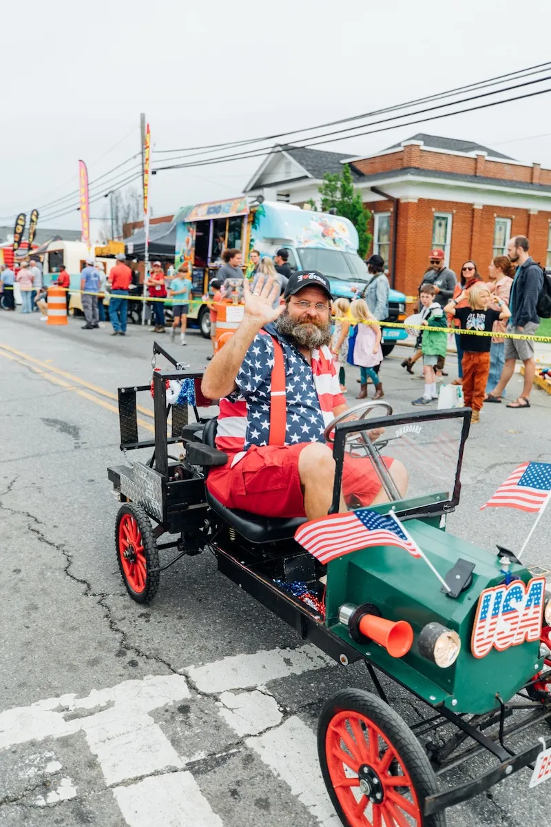 Man driving a cart during a community parade